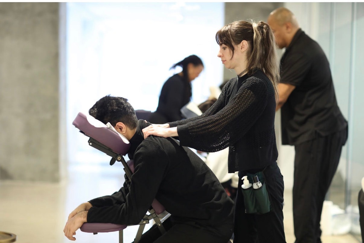 Pamper Perfect therapist delivering professional chair massage at a corporate event