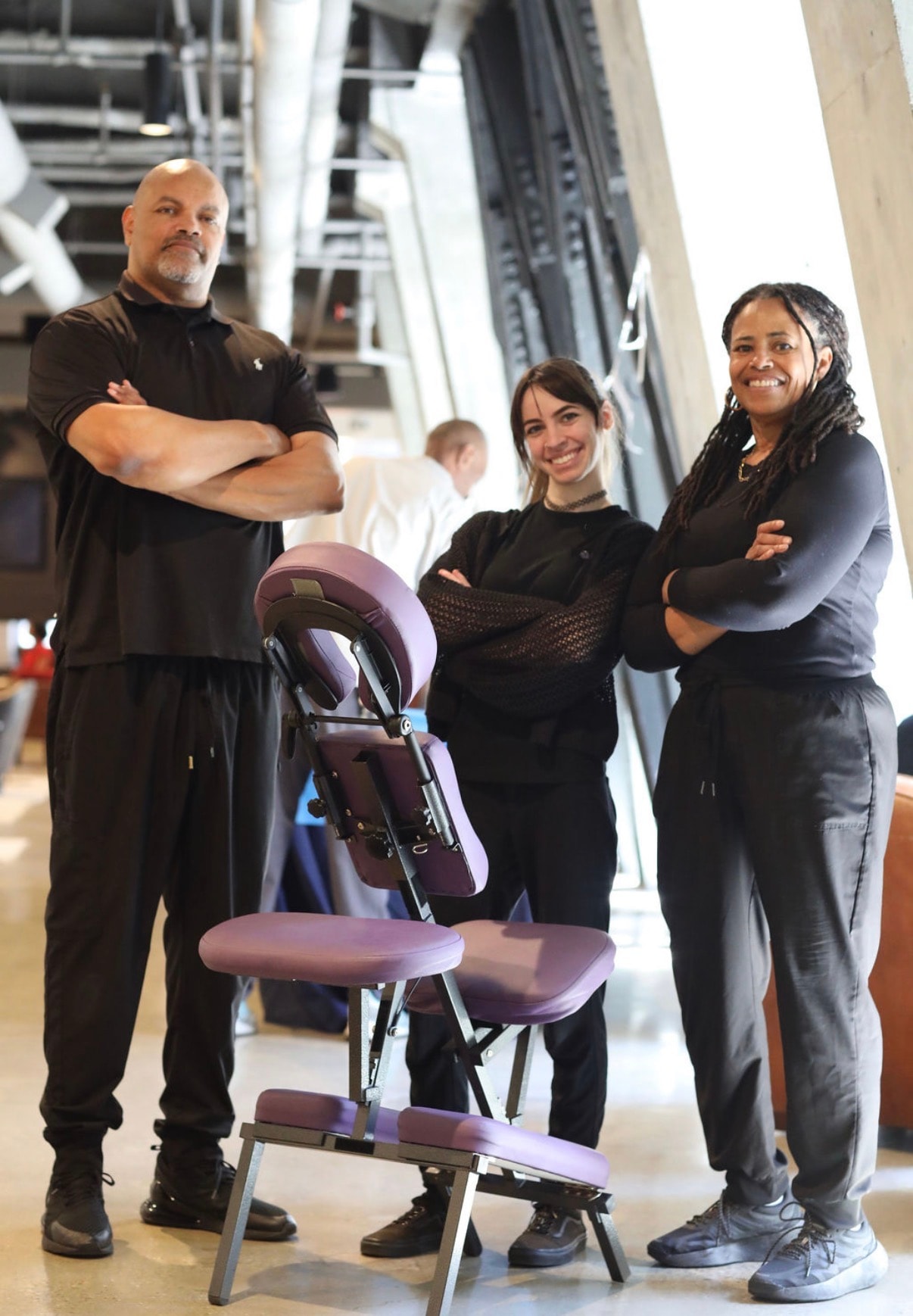 Pamper Perfect massage therapy team with chair at a corporate wellness event